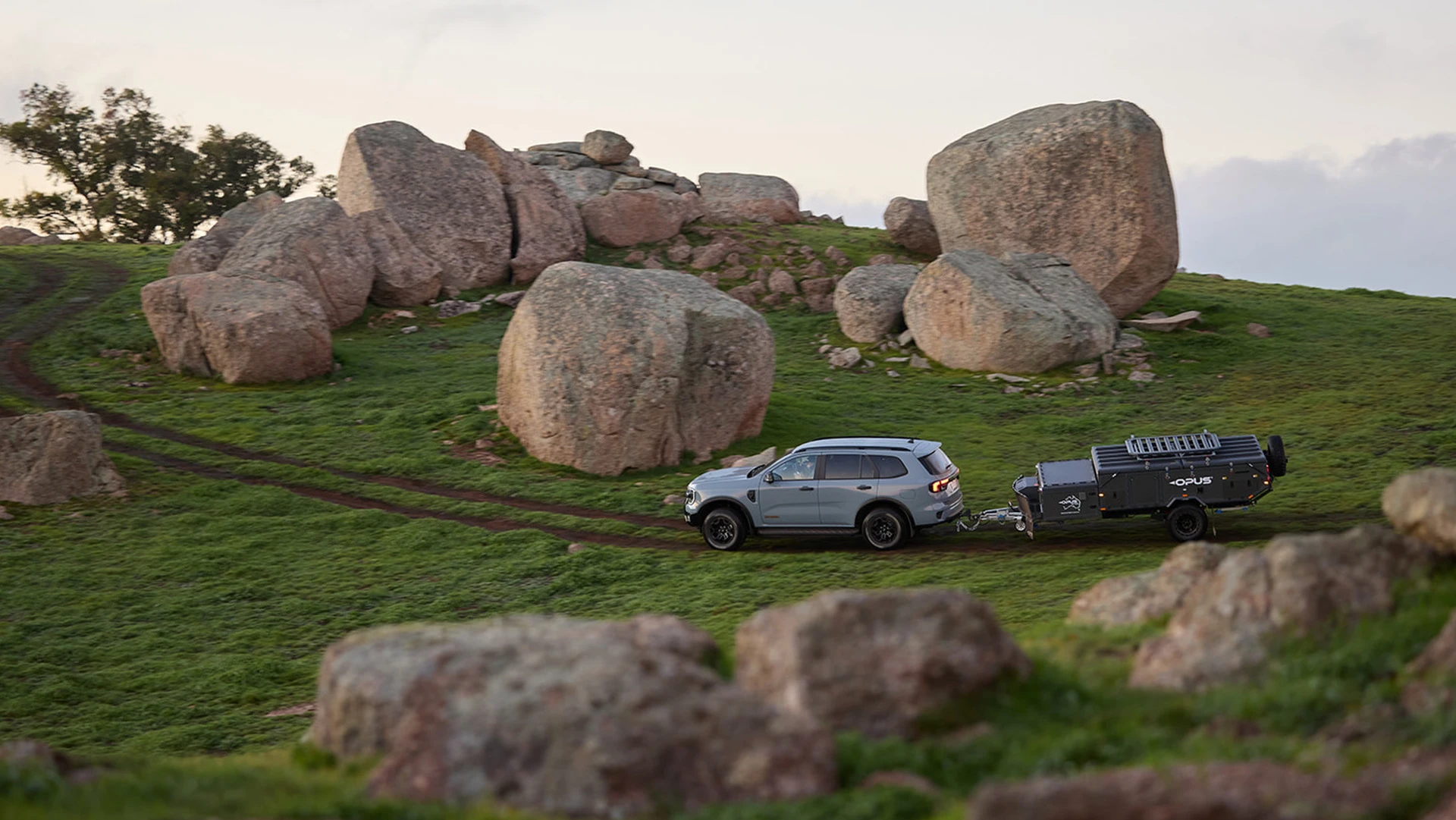 SUV towing camper through countryside