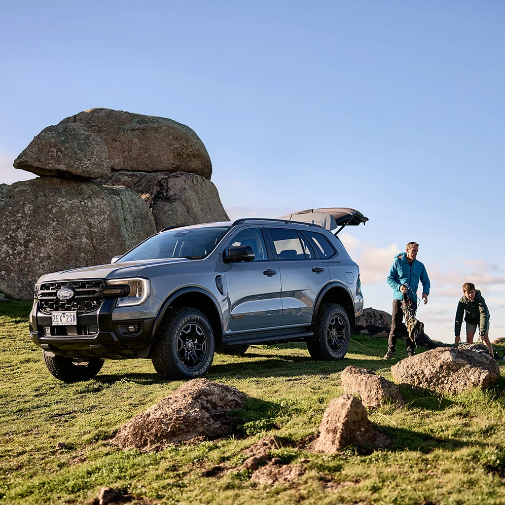 SUV parked beside hikers