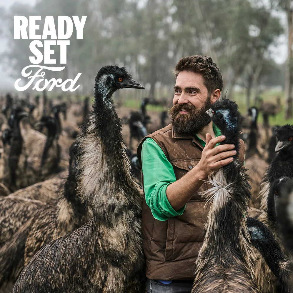 Bearded man surrounded by emus with "READY SET Ford" logo