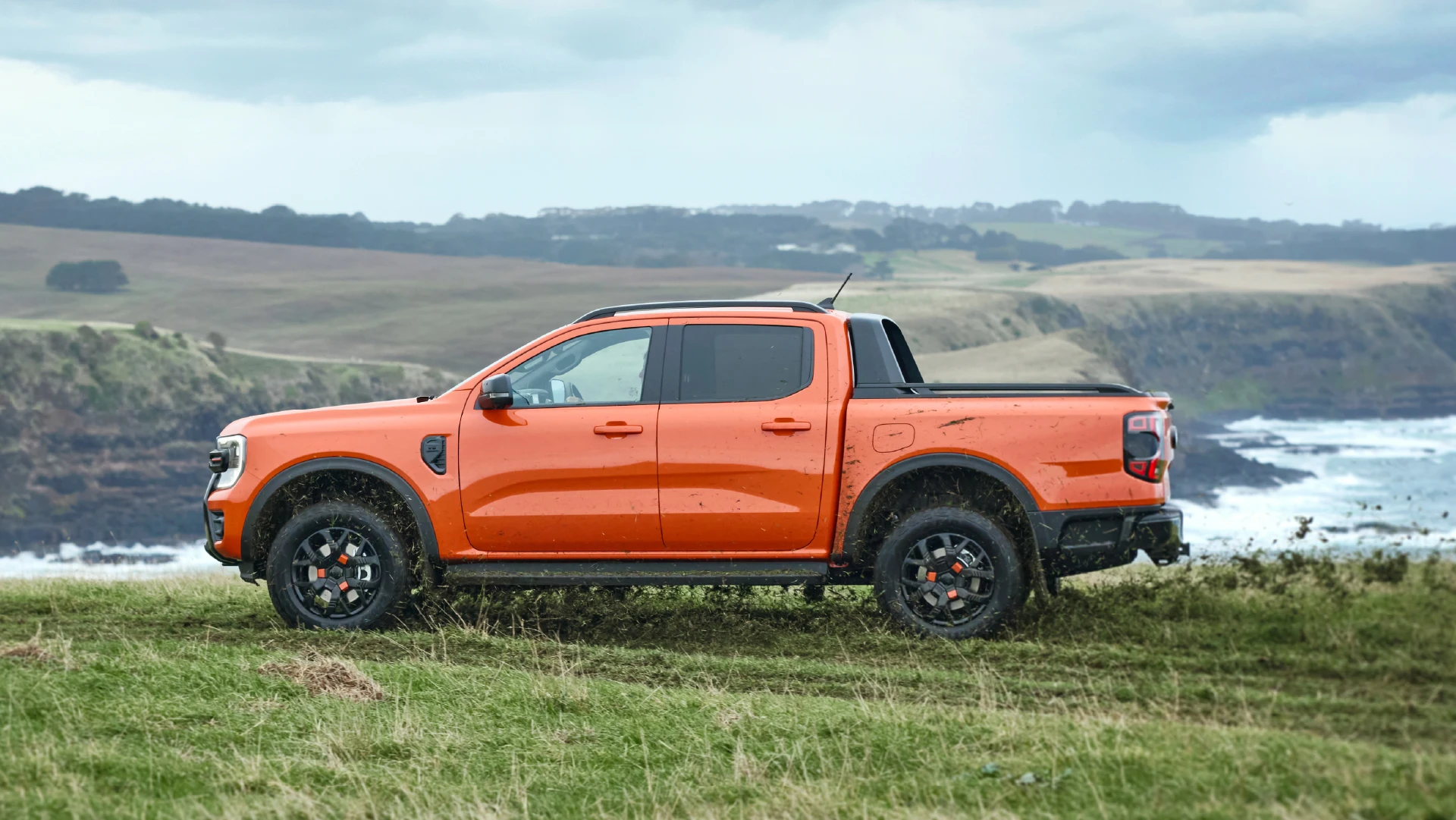 Orange pickup truck by the coast