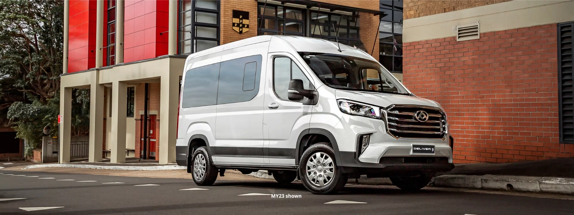 White LDV Deliver 9 Bus parked in front of brick building