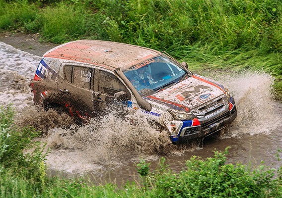 Mud-covered Isuzu MU-X drives through water crossing
