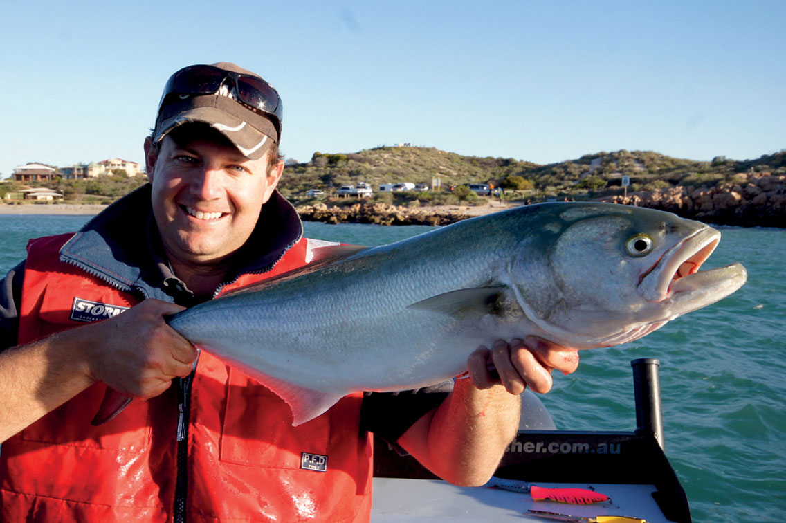 Andrew holds fish that has just been caught on the boat