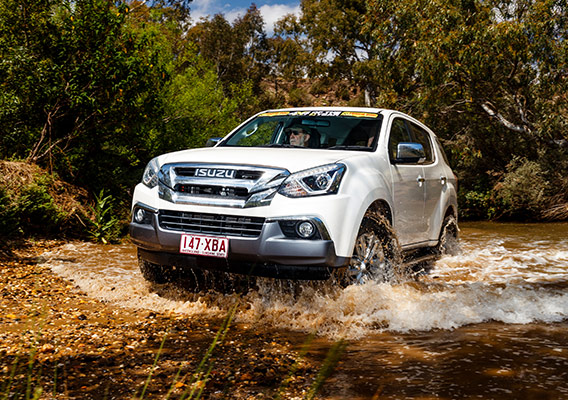 Low angle of Isuzu MU-X driving out of water crossing 