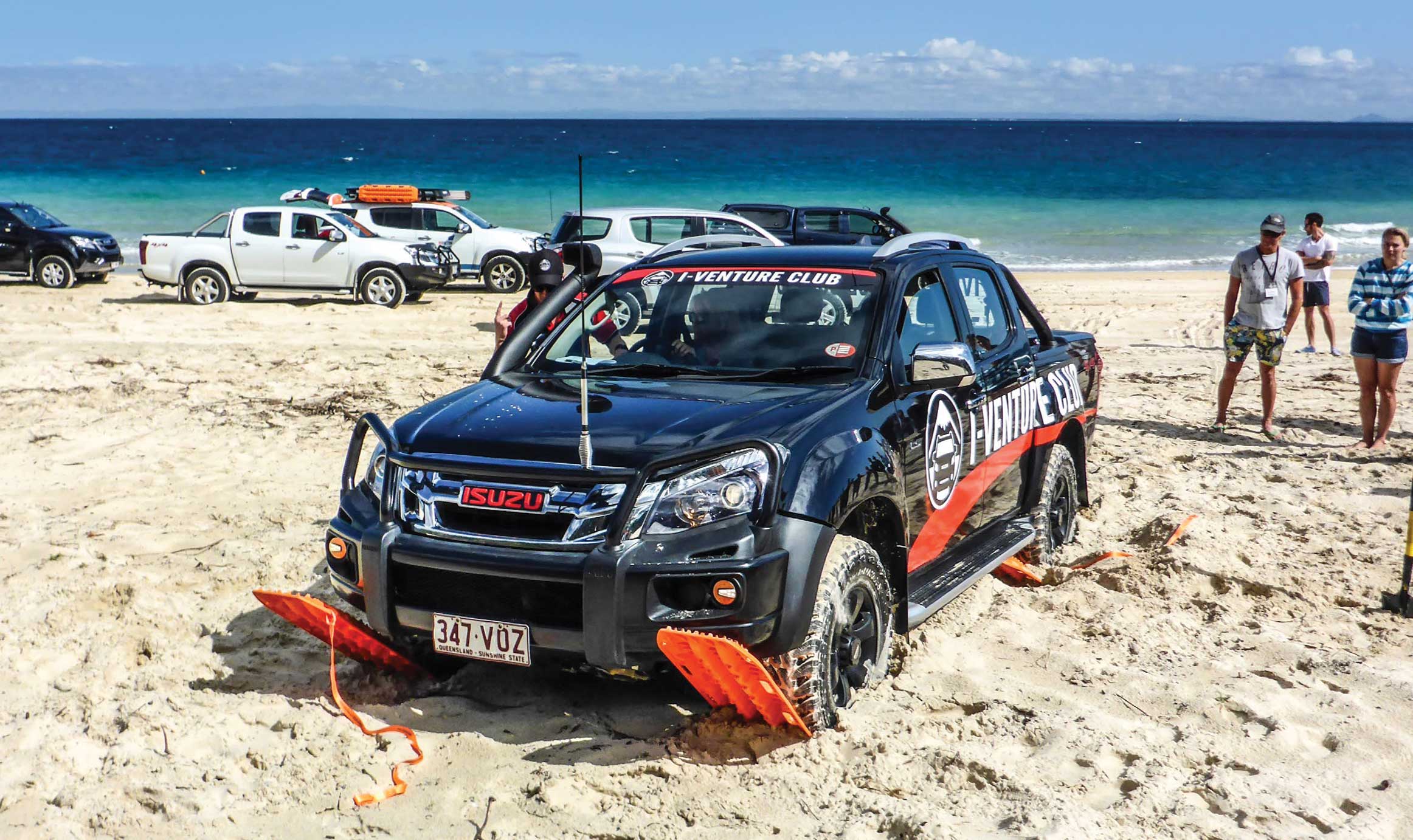 Four maxtraxs placed under each tyre of the D-MAX on a beach
