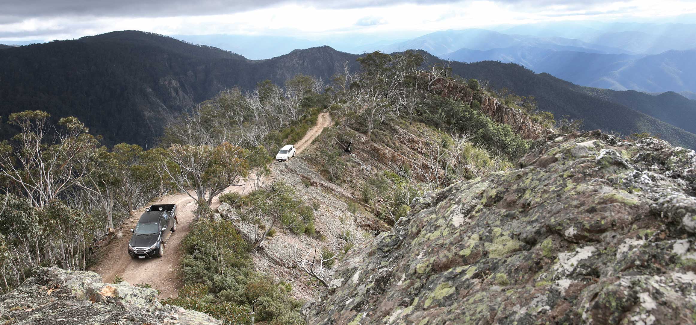 High up shot of D-MAX and MU-X driving along the ridge of a mountain top 