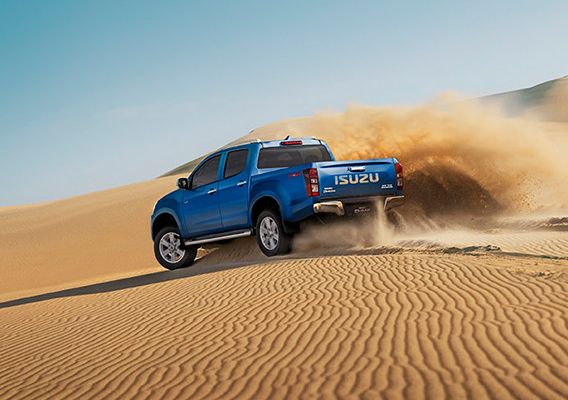 Rear view of Isuzu D-MAX skidding in desert sand