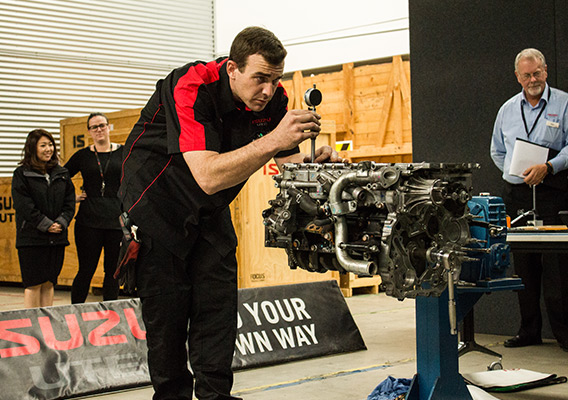 Contestant works on Isuzu Ute engine in competition