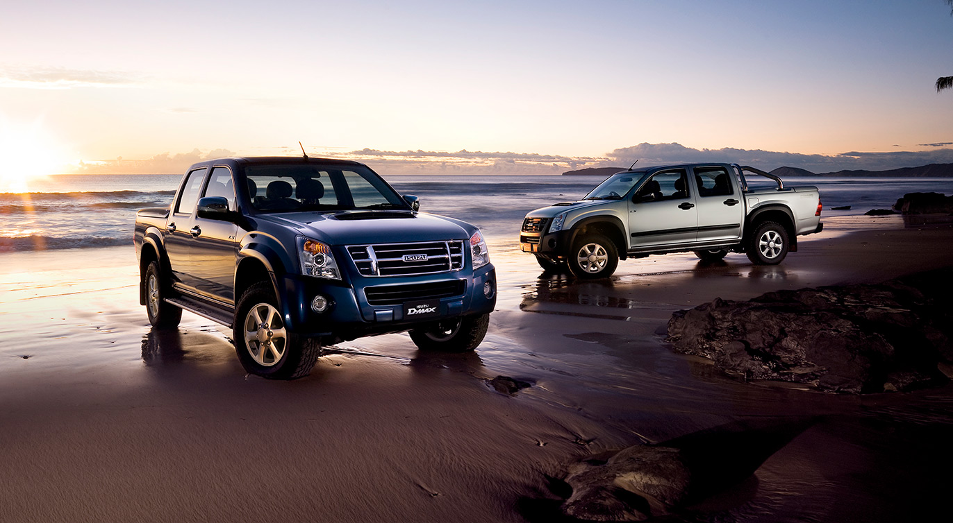 Two Isuzu D-MAXes parked on beach in early dawn