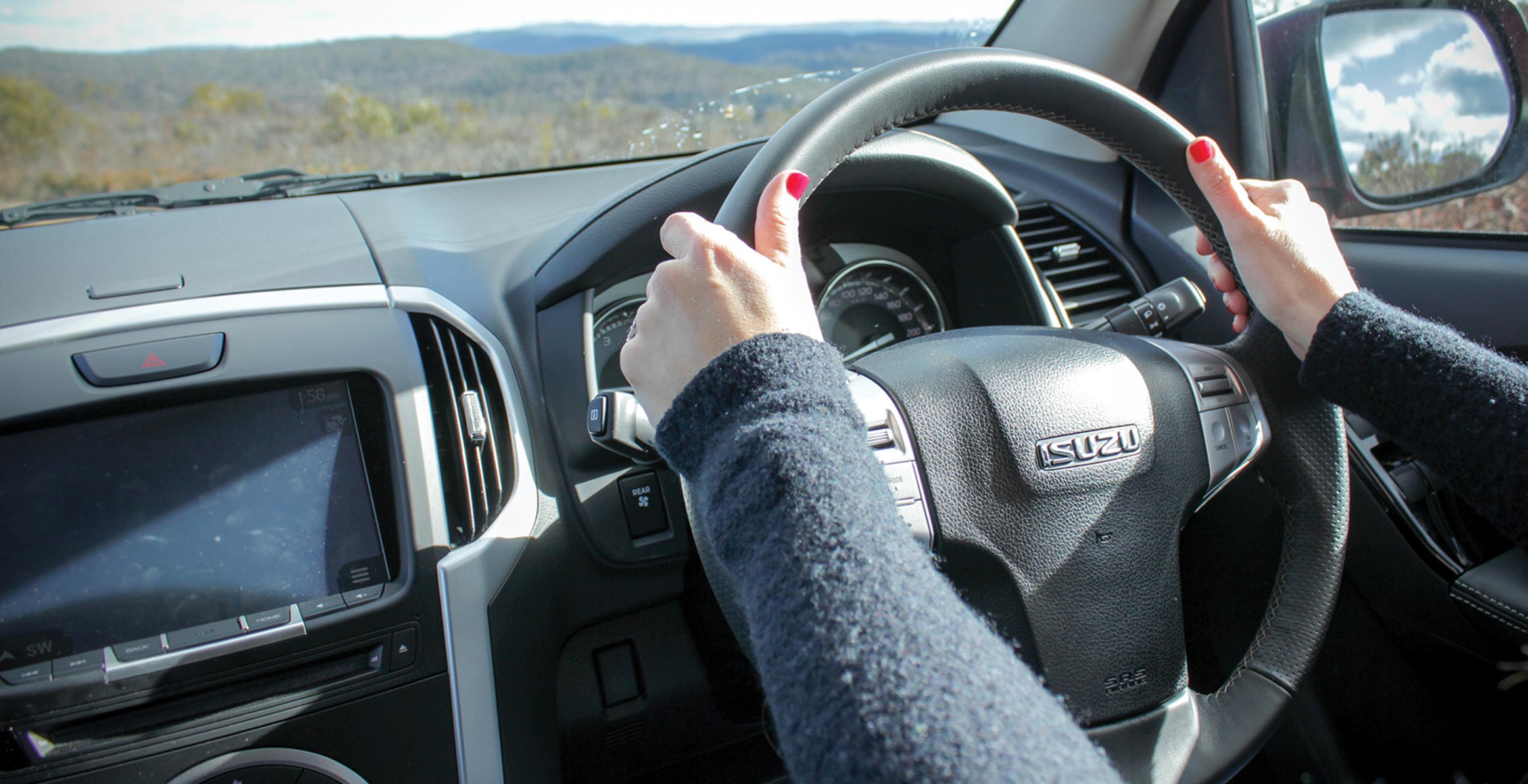 Interior view of woman driving Isuzu Ute  