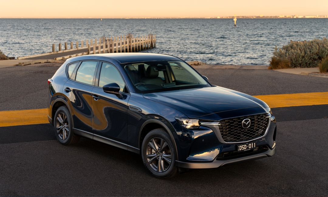 Blue Mazda CX-60 SUV parked near the waterfront at sunset in Melbourne, Victoria, Australia, showcasing modern design and premium styling.
