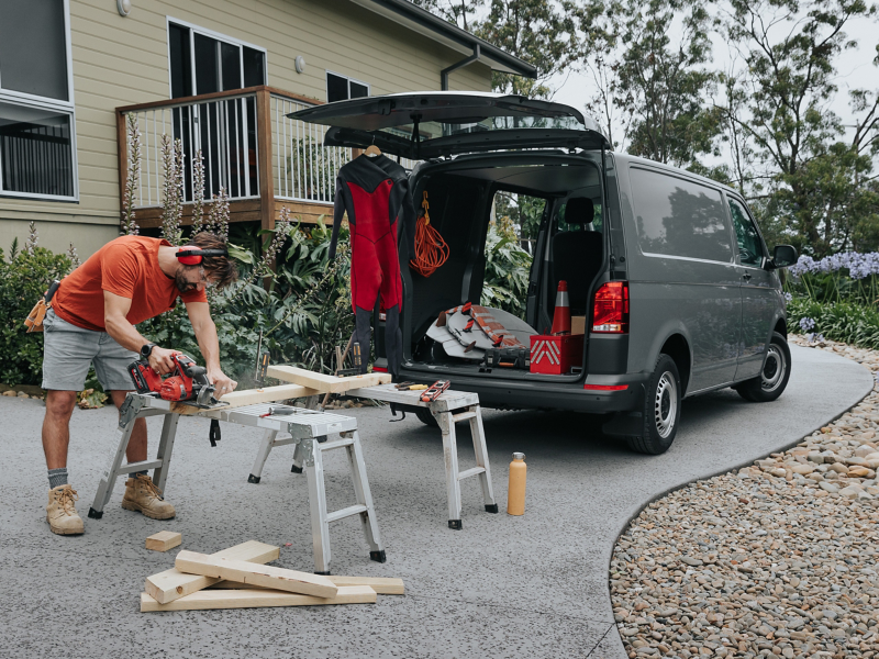 Trades man working out of Volkswagen transporter showing off exterior car features.