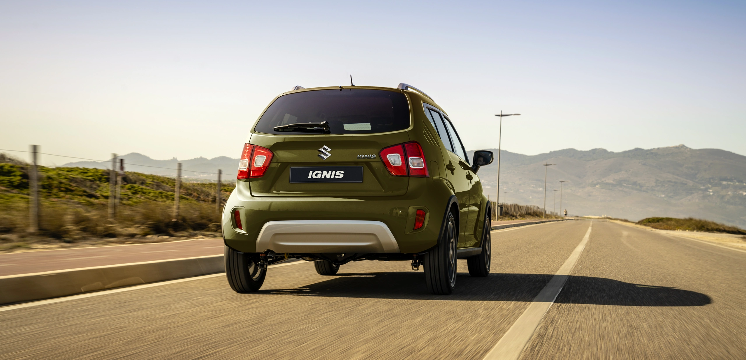 Khaki green Suzuki Ignis rear on road