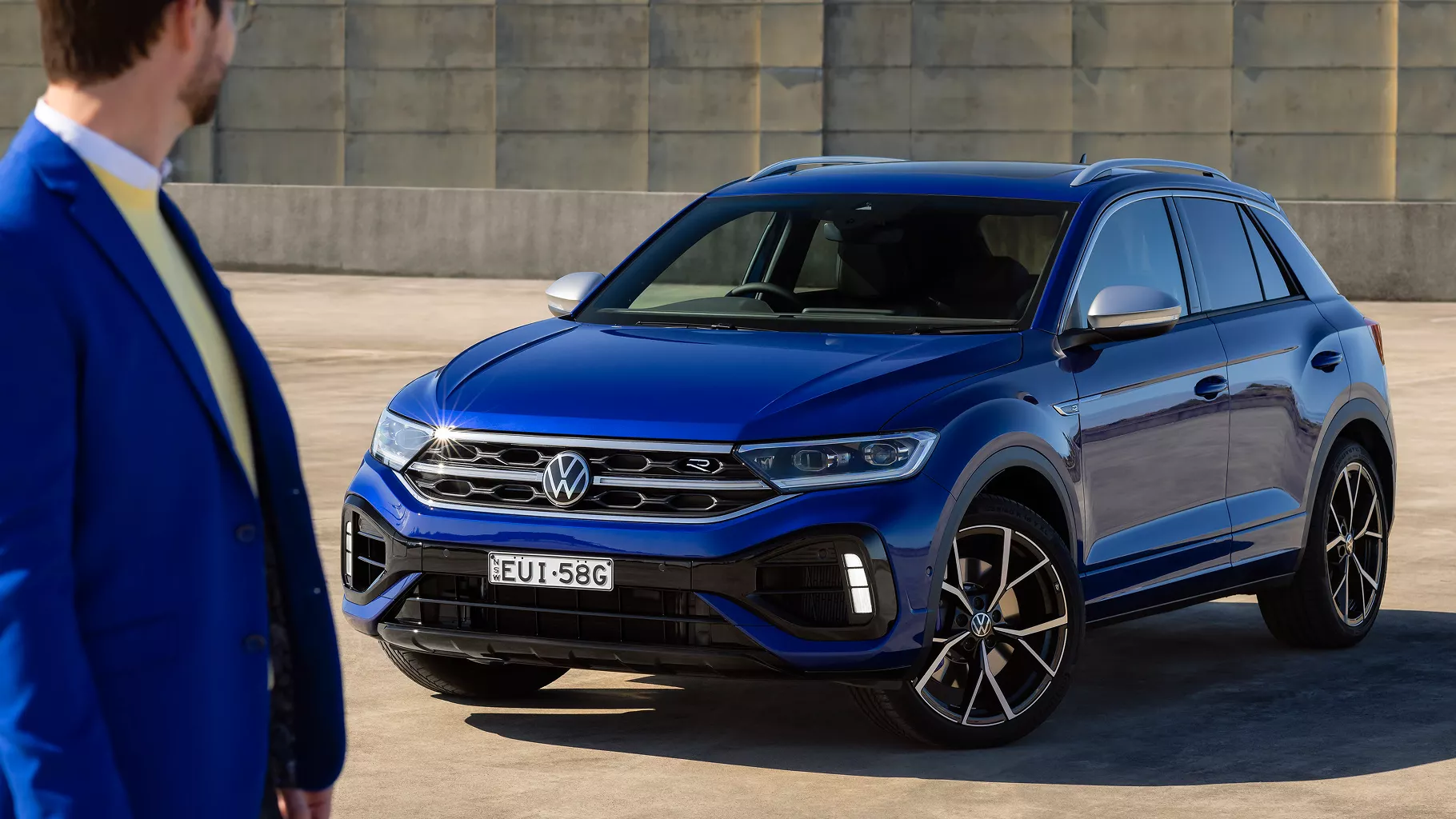 Blue T-roc R with man looking at car