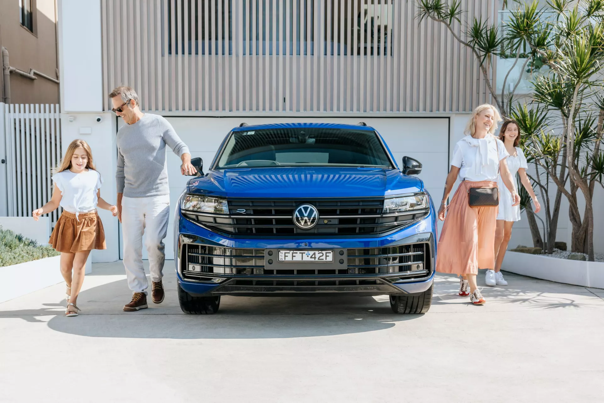 family in front of a Volkswagen Touareg